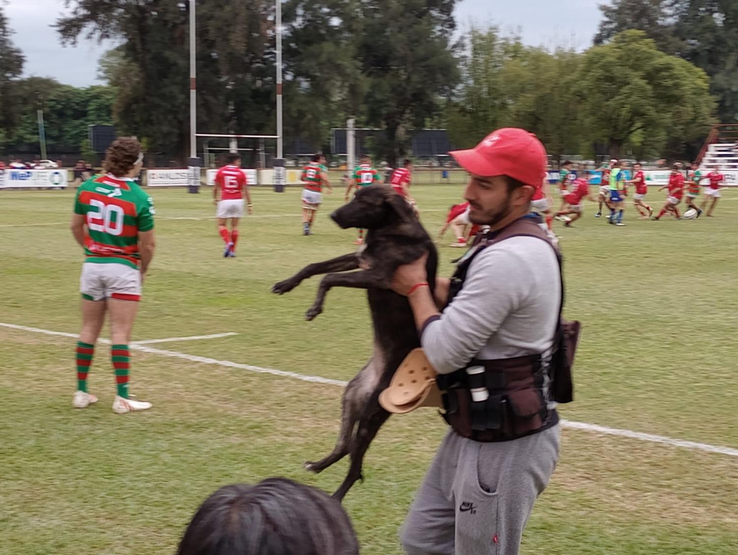 PERRO CONFISCADO. El medico del partido se lleva el perrito afuera del campo de juego. Foto: Tercer Tiempo NOA // Alvaro Jurao 